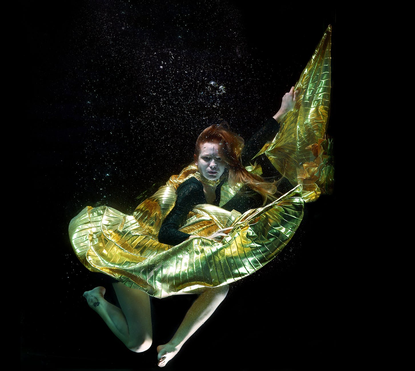underwater photo of woman wearing green and black dress